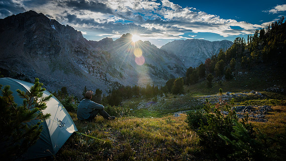 camper sitting beside tent at sunrise in mountain valley fine art landscape photograph by Richard Horst