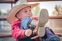 young boy cowboy adjusting boots wearing hat fine art western photograph by Richard Horst