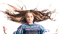 portrait of young girl with hair flying against white background fine art lifestyle photograph by Richard Horst Photography